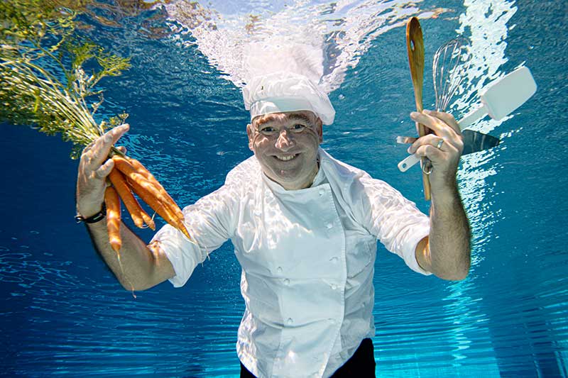 unterwasserfotografie_berufskoch-humorvoll_mit_moehren_unterwasser